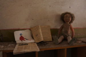 Bøker og ei dokke i ein forlatt barnehage i Tsjernobyl.